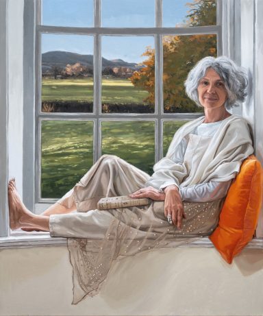 MS An oil painting of a woman with grey hair sits on a window sill, smiling, with fields visible outside. Commissioned as a gift, UK.