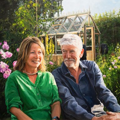 Sally and Michael A portrait painting commission of a smiling man and woman sitting in a garden with flowers and a greenhouse in the background.