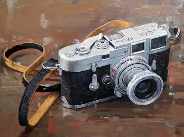 Leica camera on a wooden table with a leather strap