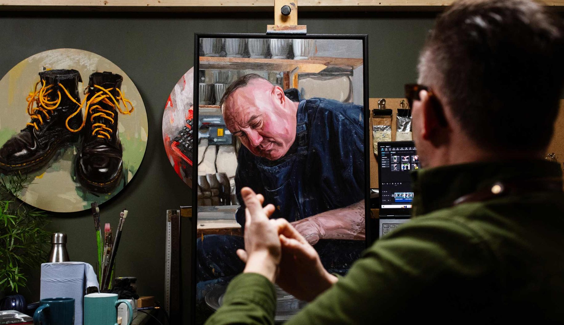 Oliver Winconek in the studio with his painting of Keith Brymer Jones. He is surrounded by art materials.